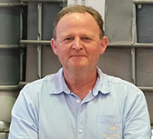 A man is standing in front of a shelf.